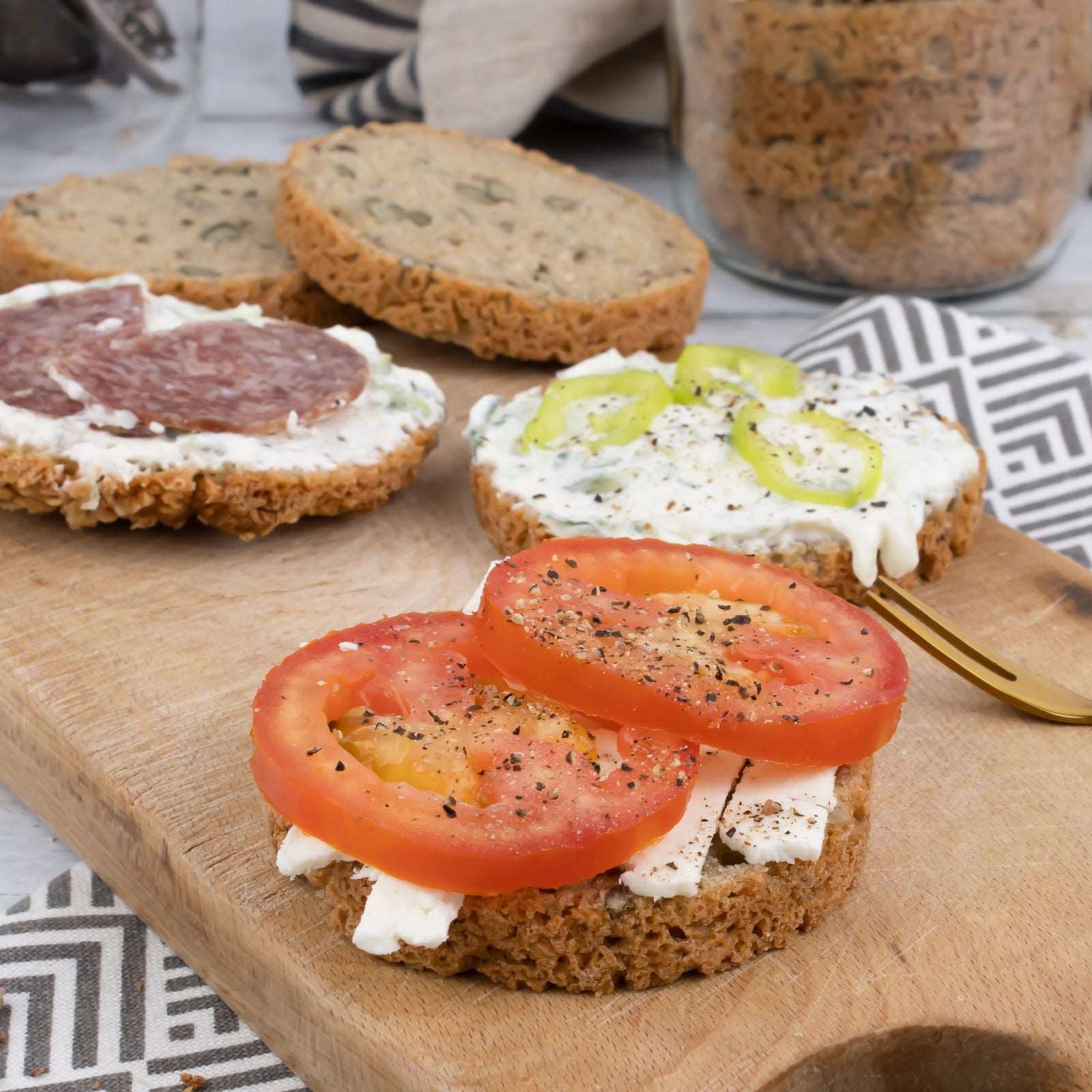 Glutenfreie Bio Backmischung Broat® – perfekt für Brot im Weckglas gebacken, ohne Zusatzstoffe, ballaststoffreich, zuckerarm und ideal für Single-Haushalte. Abgebildet als Endprodukt -  das Kernige - runde glutenfreie Brot Scheiben mit Belag